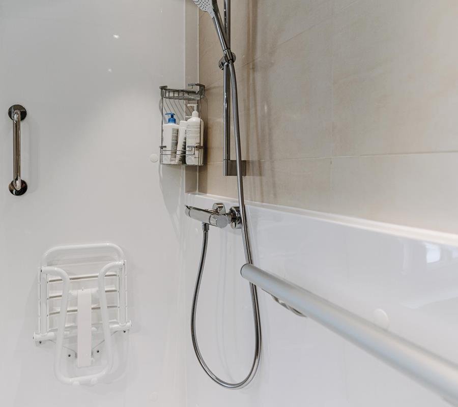 detailed view of a high-quality chrome safety grab bar installed on a designer bathroom wall